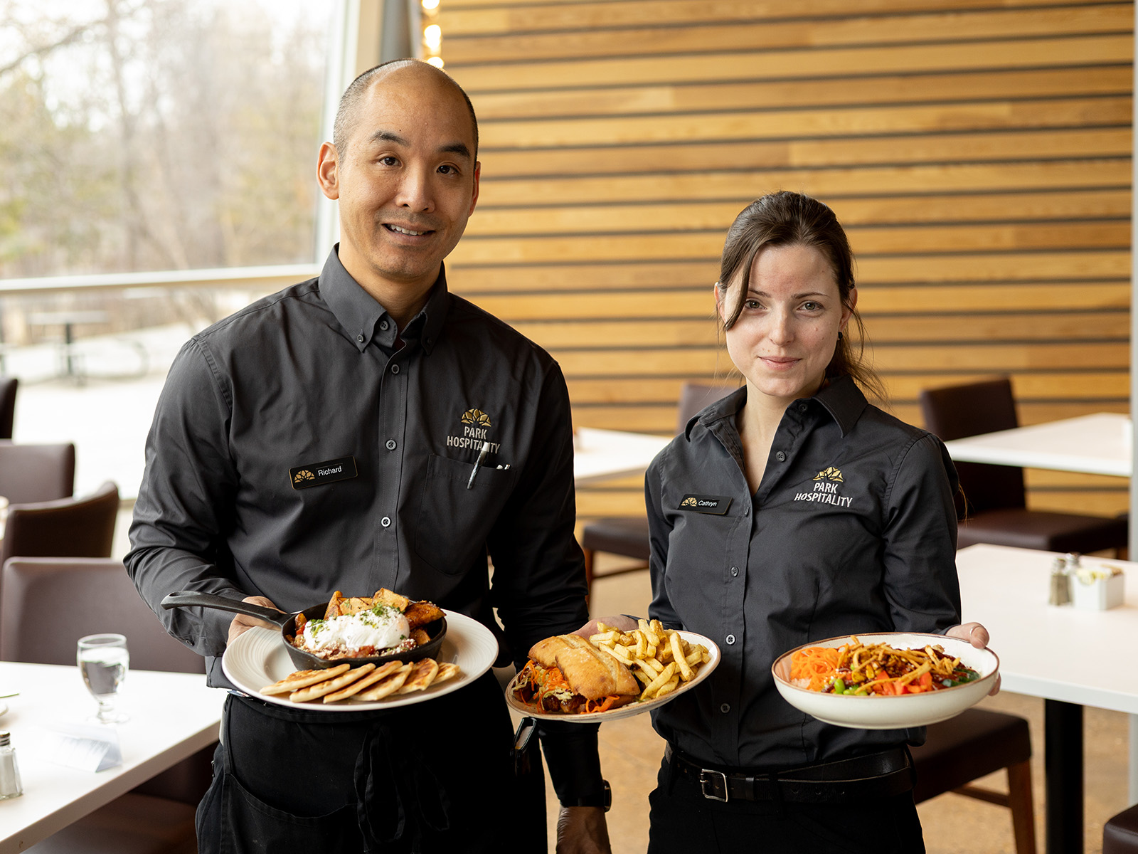 two servers hold plates of food